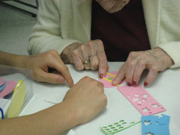Intergenerational program volunteers at an Easter event A senior and a student making an Easter egg